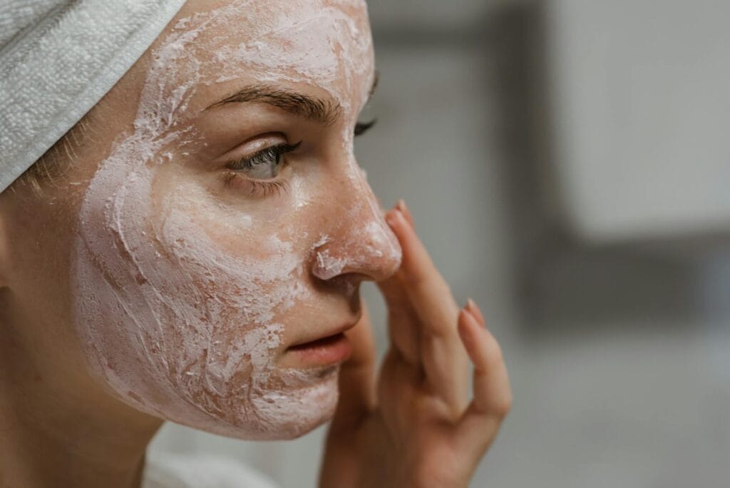 Close-up of a woman applying facial cream as part of her skincare routine, enhancing skin health. brigtening.