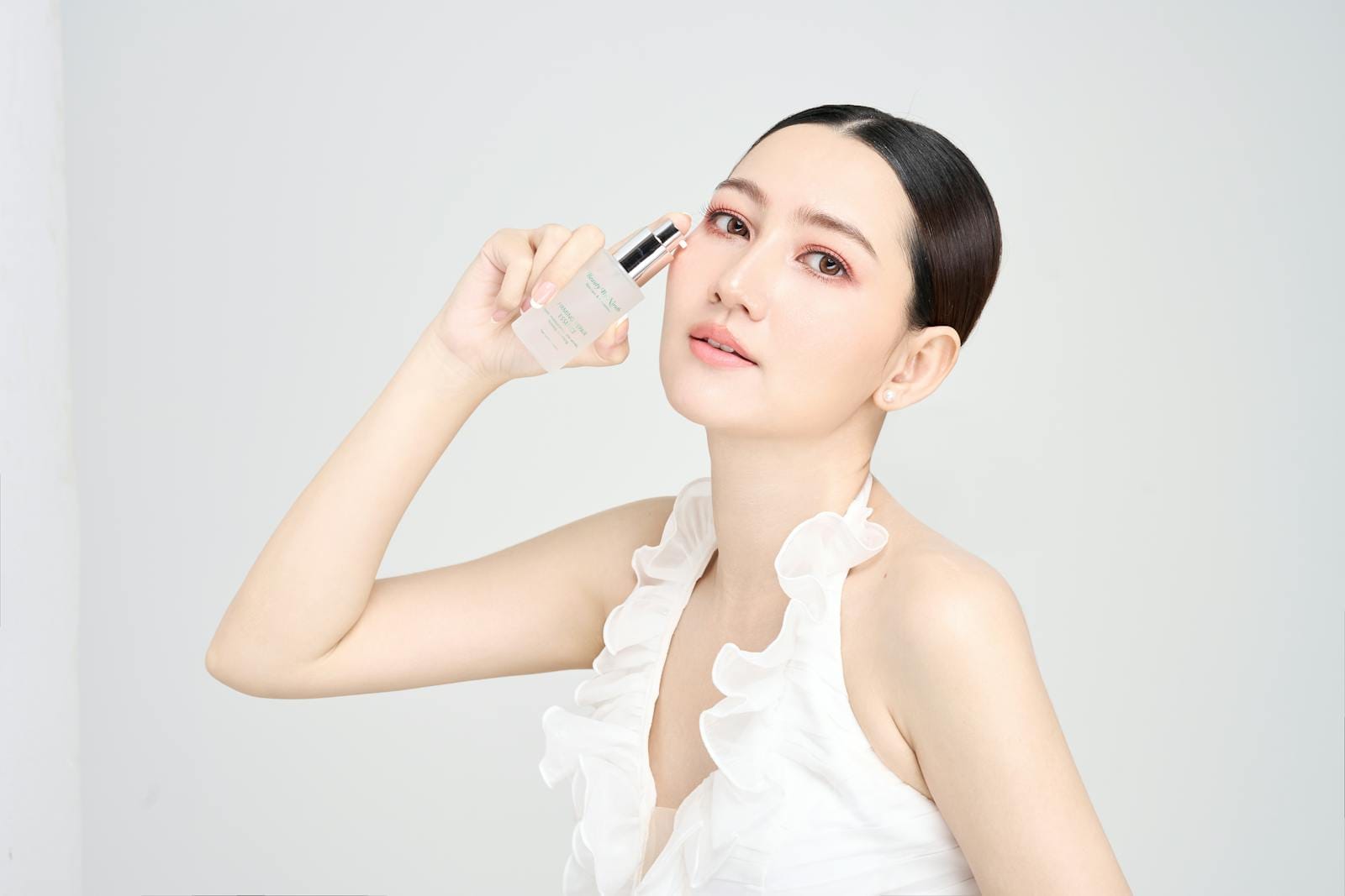 Serene model holding skincare product in modern beauty photoshoot. skincare overclaim.