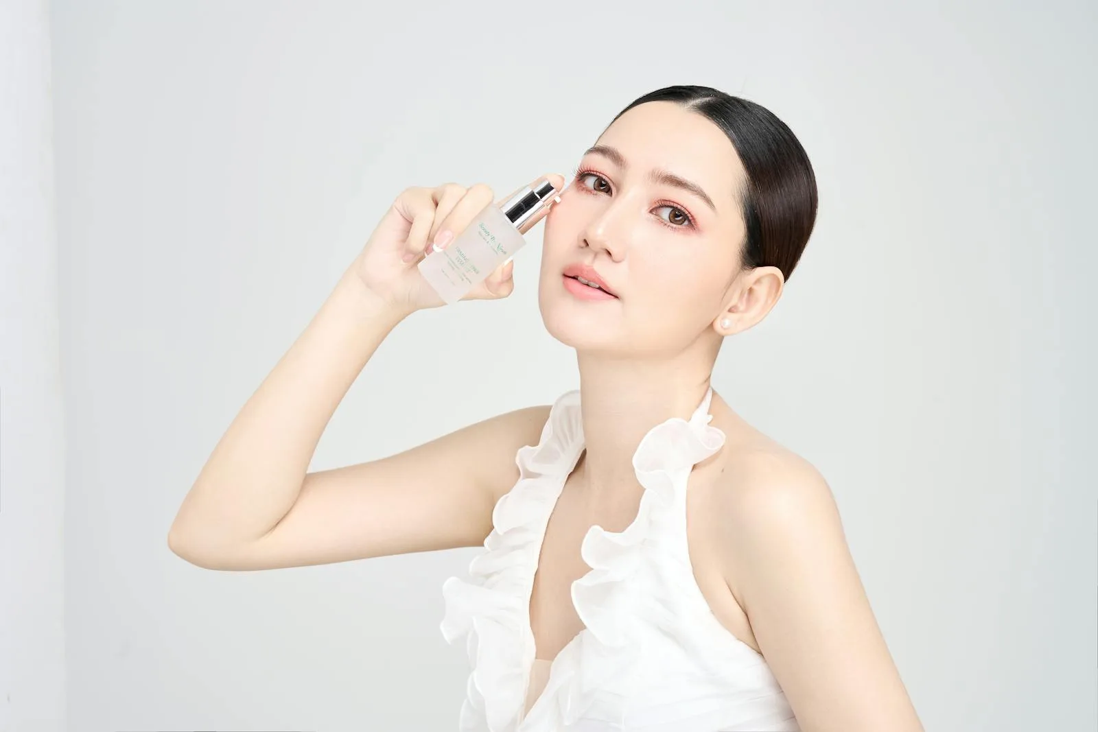 Serene model holding skincare product in modern beauty photoshoot. skincare overclaim.