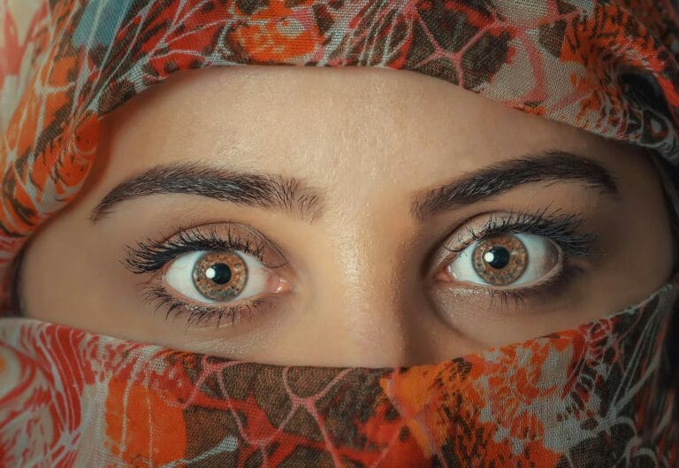 A striking close-up shot of a woman's eyes framed by a colorful headscarf, capturing beauty and mystery.