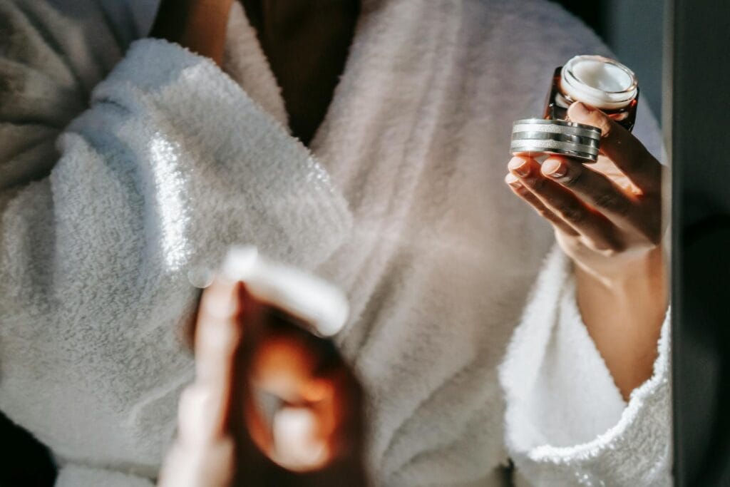 Woman in bathrobe applying skincare cream for a calm morning routine. Doctor-Prescribed Creams