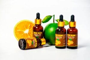 Vitamin C serum bottles with fresh citrus fruits for skincare and health promotion.