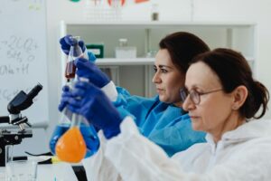 Two scientists in a lab conducting experiments with colored liquids in flasks, using PPE. pesticide.